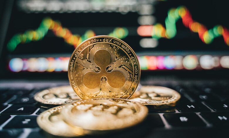 Golden Ripple XRP coins on laptop, symbolizing cryptocurrency trends and online trading.